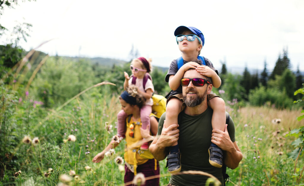 Eine Familie mit Kindern genießt das sonnige Wetter bei einer Wanderung