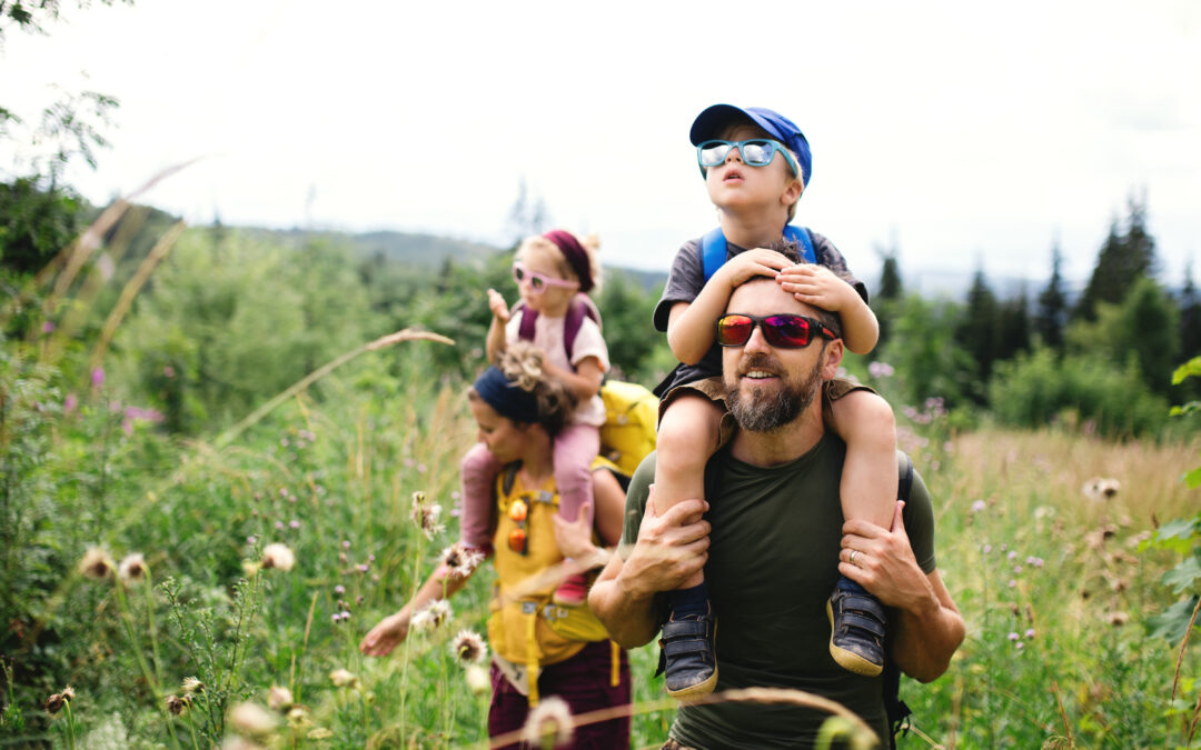 Eine Familie mit Kindern genießt das sonnige Wetter bei einer Wanderung