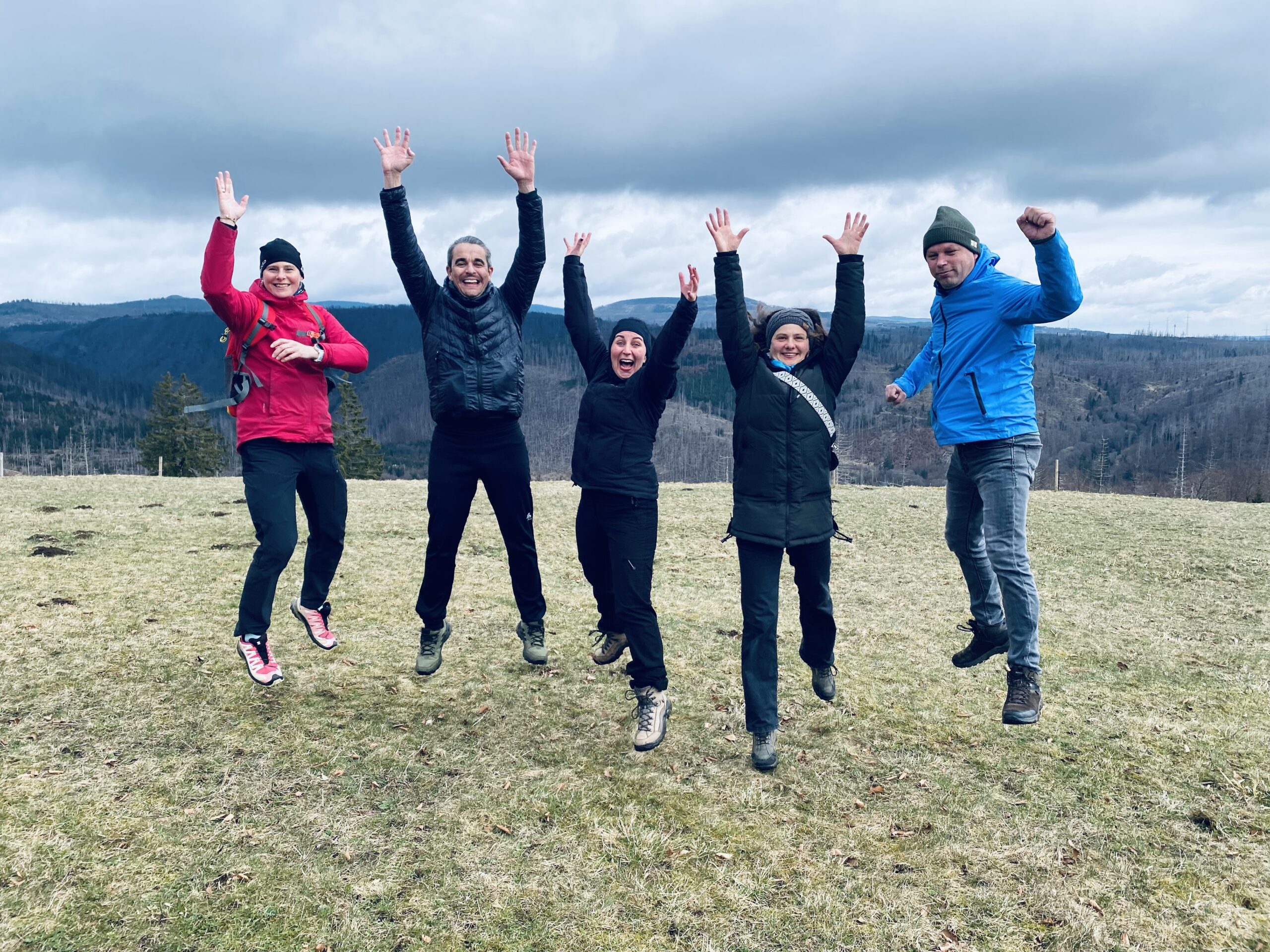 Eine Wandergruppe springt fröhlich in die Luft